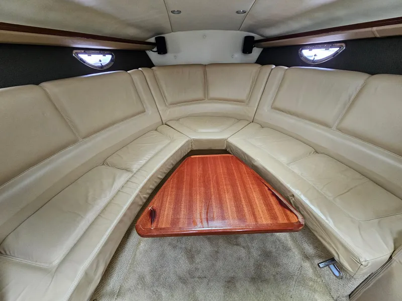 Slide: The Image of 2007 Cobalt 323 boat interior with beige leather seating and wooden table. - 6
