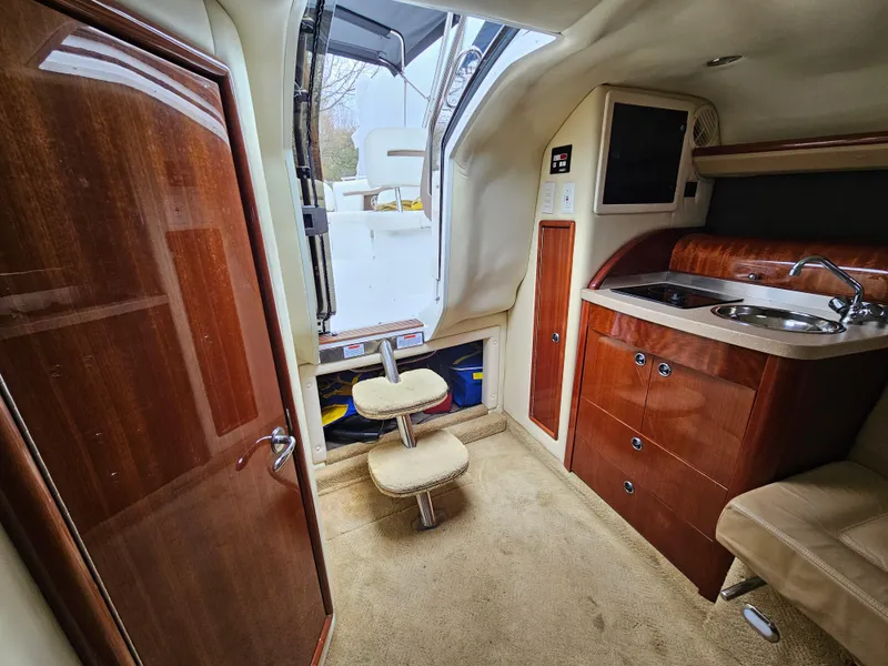 Slide: The Image of Interior of a 2007 Cobalt 323 boat with wooden cabinetry and compact kitchen. - 7