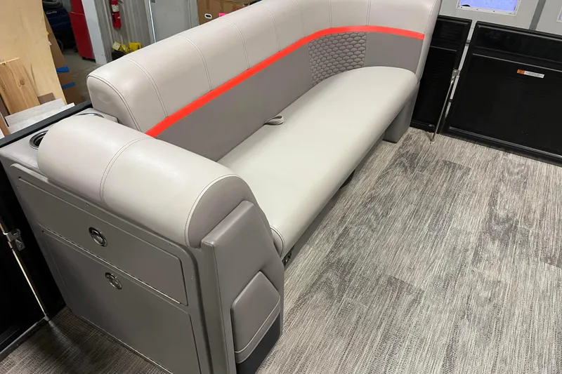 Slide: The Image of 2024 Angler Qwest 8522 LTZ Fish N Ski boat interior with gray seating and red accents. - 14