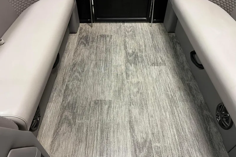 Slide: The Image of 2024 Angler Qwest 8522 LTZ Fish N Ski interior with gray flooring and cushioned seating. - 18