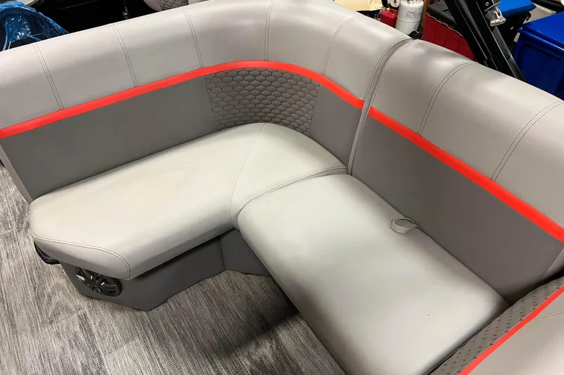 Slide: The Image of 2024 Angler Qwest 8522 LTZ Fish N Ski boat seating with gray upholstery and red accents. - 27