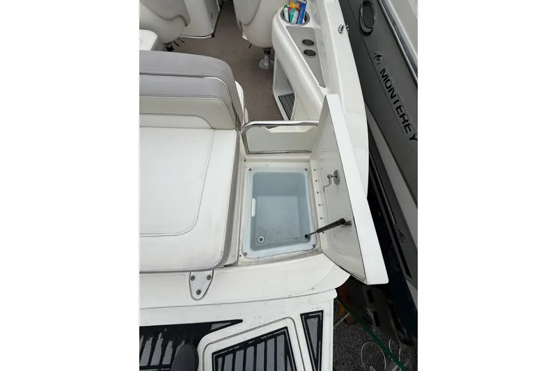 Slide: The Image of 2012 Sea Ray 240 Sundeck interior with open storage compartment and seating area. - 22