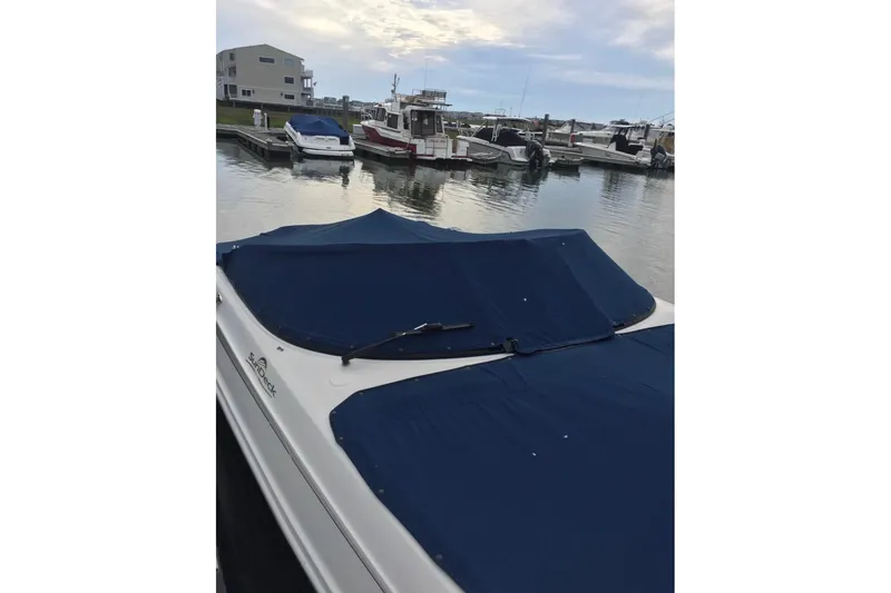 Slide: The Image of 2012 Searay 240 boat docked with blue cover in marina. - 3