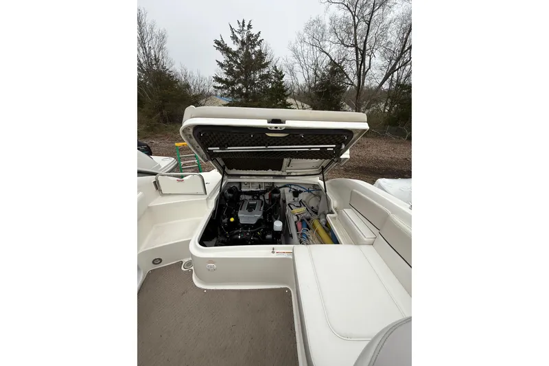 Slide: The Image of 2012 Sea Ray 240 Sundeck boat engine compartment with open hatch, outdoor setting. - 30
