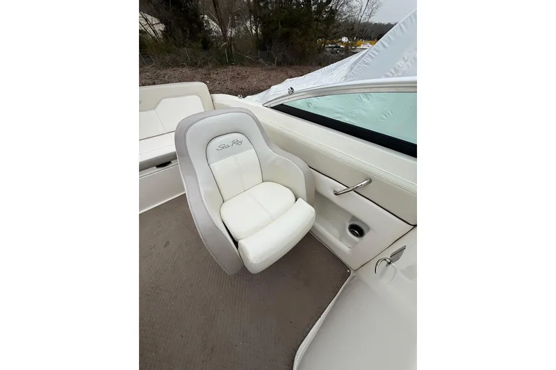 Slide: The Image of 2012 Sea Ray 240 Sundeck interior with white cushioned seating and sleek design. - 33