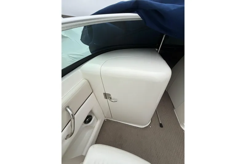 Slide: The Image of Interior view of a 2012 Sea Ray 240 Sundeck boat, featuring white seating and storage. - 35