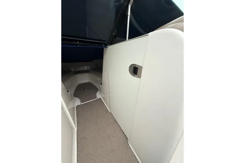 Slide: The Image of Interior view of 2012 Sea Ray 240 Sundeck boat with carpeted flooring. - 36