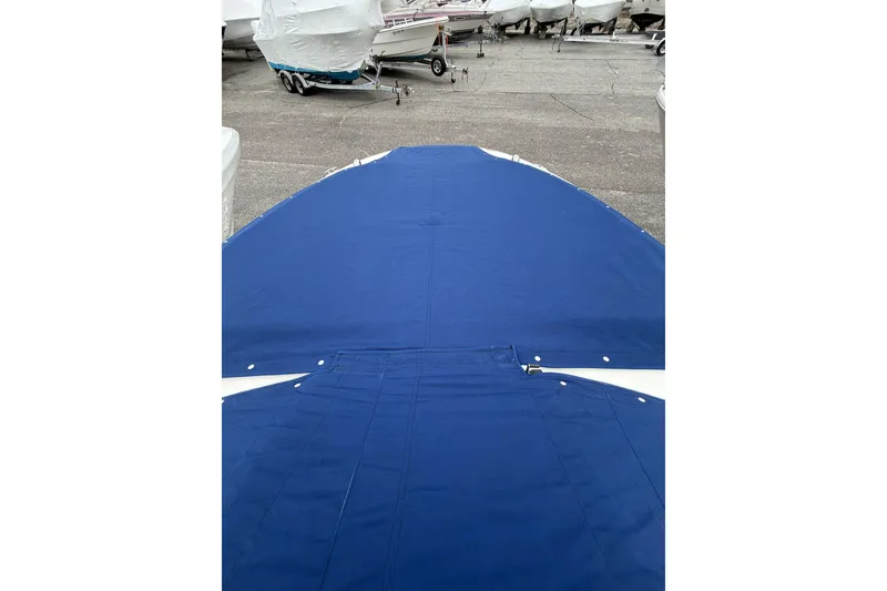Slide: The Image of Blue cover on 2012 Sea Ray 240 Sundeck boat, parked among other boats. - 44