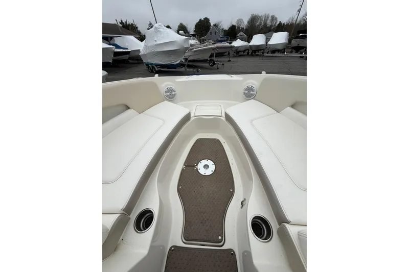 Slide: The Image of 2012 Sea Ray 240 Sundeck boat interior with white seating and brown flooring. - 45