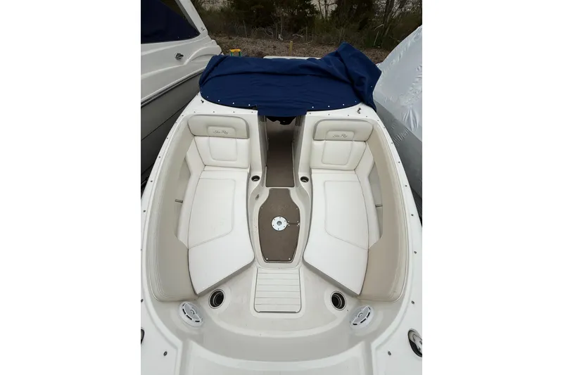 Slide: The Image of 2012 Sea Ray 240 Sundeck boat interior with white seating and blue cover. - 46