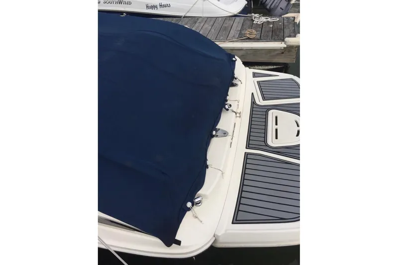Slide: The Image of Covered 2012 Searay 240 boat docked at marina with calm water. - 5