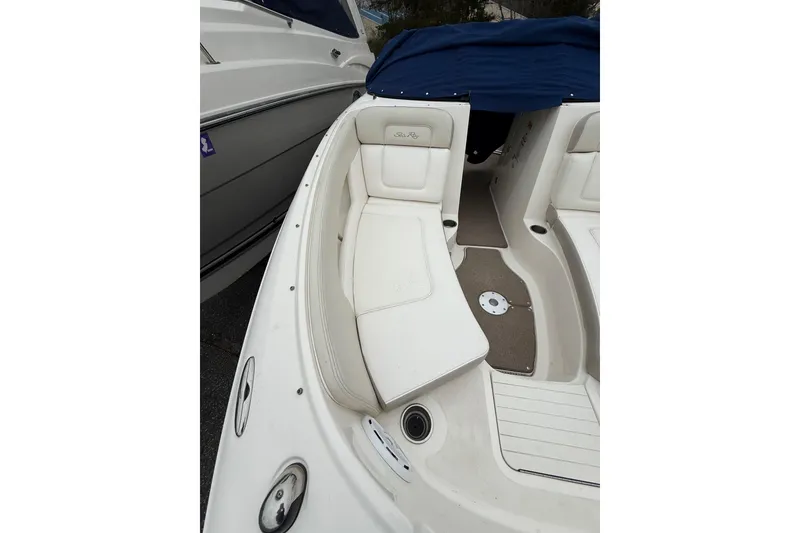 Slide: The Image of 2012 Sea Ray 240 Sundeck boat interior with white seating and blue cover. - 50