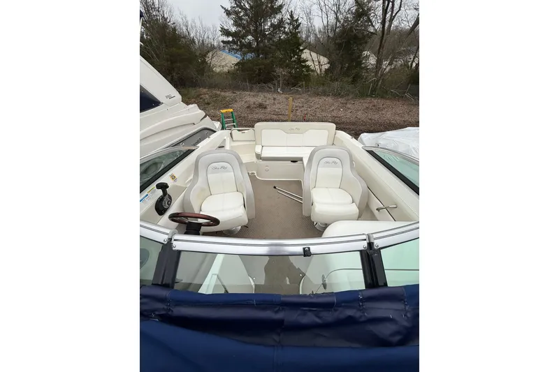 Slide: The Image of 2012 Sea Ray 240 Sundeck boat interior with white seating and steering wheel. - 56