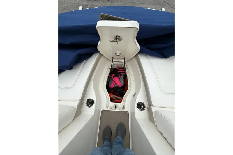 Slide: The Image of 2012 Sea Ray 240 Sundeck interior storage compartment with life jackets. - 57
