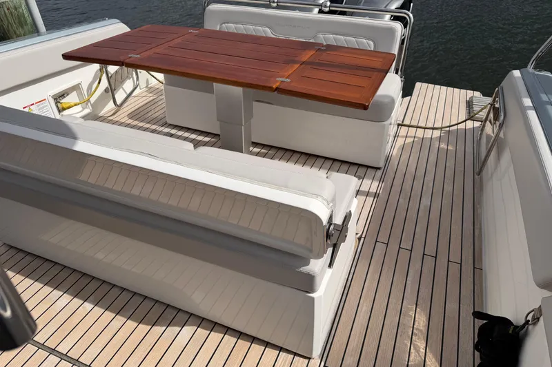 Slide: The Image of 2023 Schaefer V33 yacht interior with wooden table and cushioned seating. - 13