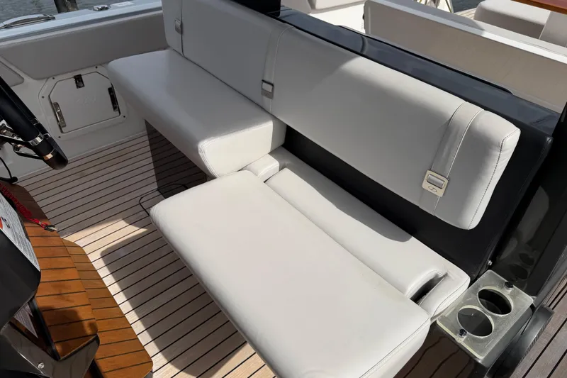Slide: The Image of 2023 Schaefer V33 boat interior with white cushioned seating and wooden flooring. - 14