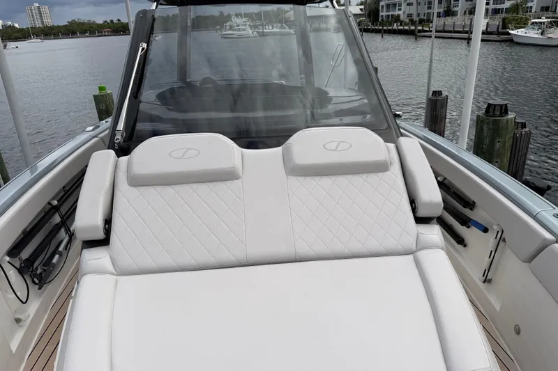 Slide: The Image of 2023 Schaefer V33 boat with luxurious white seating, docked by the waterfront. - 17
