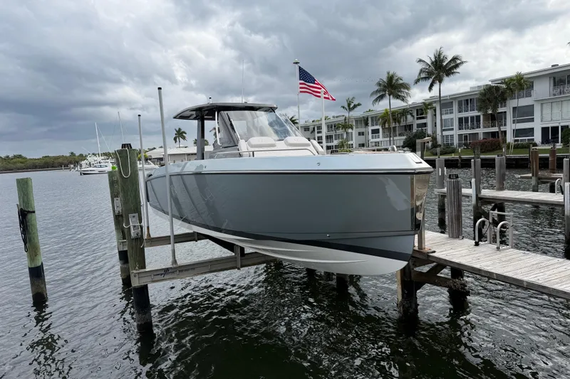 Slide: The Image of 2023 Schaefer V33 boat docked, with American flag, under cloudy skies. - 3