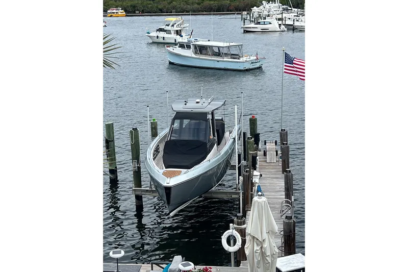 Slide: The Image of 2023 Schaefer V33 boat docked at marina with American flag nearby. - 6