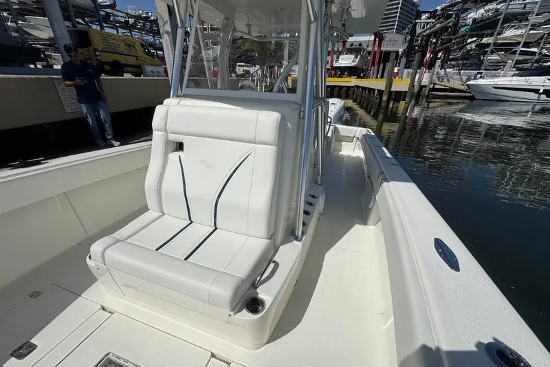 Slide: The Image of 2014 SeaVee 340B Open boat with white seating, docked at a marina. - 15