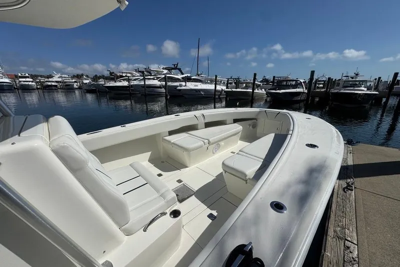 Slide: The Image of 2014 SeaVee 340B Open boat docked at marina, featuring spacious seating and clear skies. - 16
