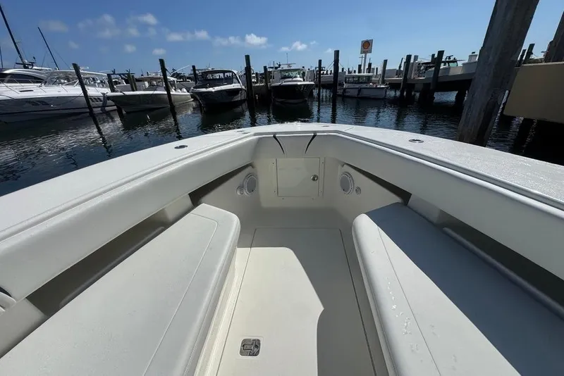 Slide: The Image of 2014 SeaVee 340B Open boat interior at marina, showcasing spacious seating and clear skies. - 18
