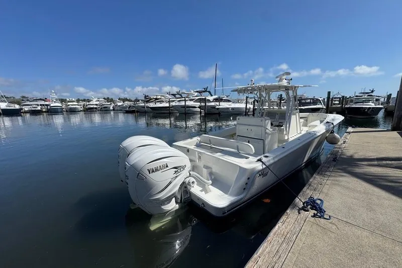 Slide: The Image of 2014 SeaVee 340B Open boat docked with Yamaha engines, clear sky, marina background. - 4