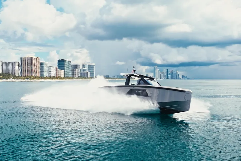 Slide: The Image of 2024 Maori 46ft yacht cruising near city skyline under cloudy skies. - 2