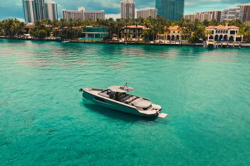 Slide: The Image of 2024 Maori 46ft yacht on turquoise water with city skyline backdrop. - 5