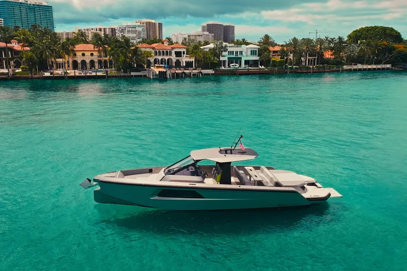 Slide: The Image of 2024 Maori 46ft yacht on turquoise water near luxury waterfront homes. - 8