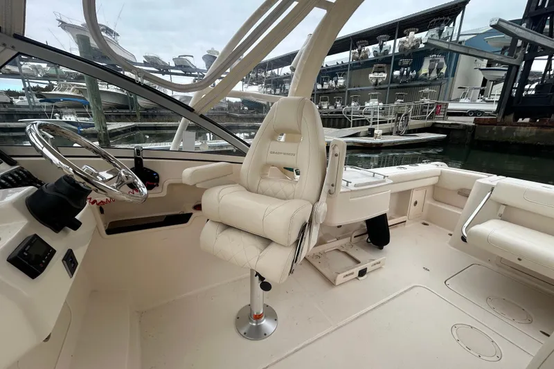 Slide: The Image of 2022 Grady-White Freedom 235 boat interior with helm and seating at marina. - 11