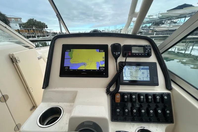 Slide: The Image of 2022 Grady-White Freedom 235 boat dashboard with navigation and control systems. - 13