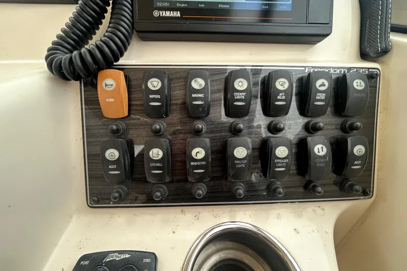 Slide: The Image of Control panel of a 2022 Grady-White Freedom 235 boat with labeled switches. - 16