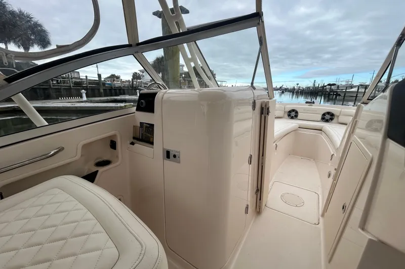 Slide: The Image of 2022 Grady-White Freedom 235 boat interior with seating and storage, docked by the marina. - 17