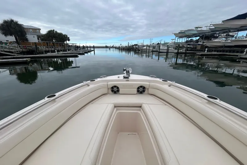 Slide: The Image of 2022 Grady-White Freedom 235 boat docked in a serene marina setting. - 19