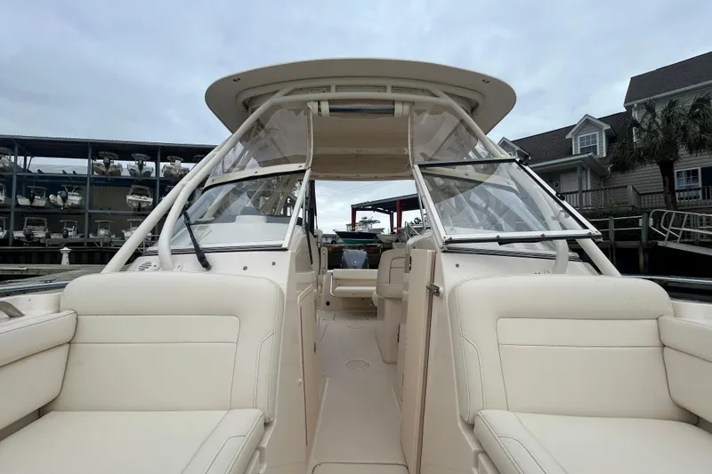 Slide: The Image of 2022 Grady-White Freedom 235 boat interior with seating and windshield, docked at marina. - 20
