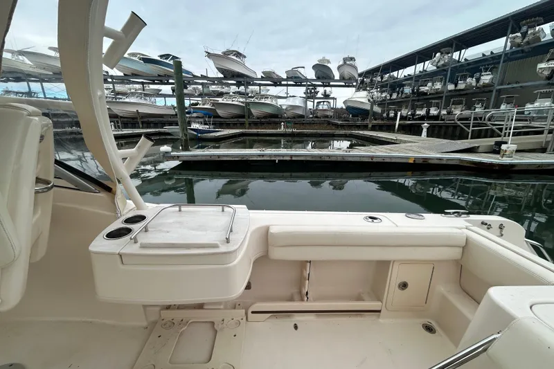 Slide: The Image of 2022 Grady-White Freedom 235 boat interior at marina with docked boats in background. - 7
