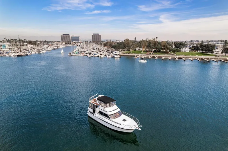 Slide: The Image of 1988 Marine Trader Trawler in a scenic marina with clear blue skies. - 2
