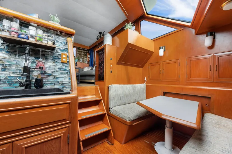 Slide: The Image of 1988 Marine Trader Trawler interior with wooden cabinetry, dining area, and modern kitchen amenities. - 20