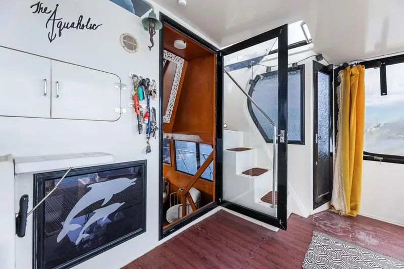 Slide: The Image of 1988 Marine Trader Trawler interior with stairs, dolphin artwork, and nautical decor. - 27
