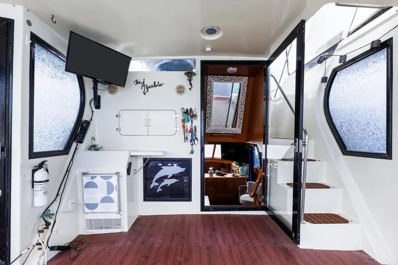 Slide: The Image of 1988 Marine Trader Trawler interior with modern decor, TV, and nautical accents. - 28
