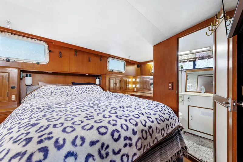 Slide: The Image of 1988 Marine Trader Trawler bedroom with leopard print bedding and wooden interior. - 29