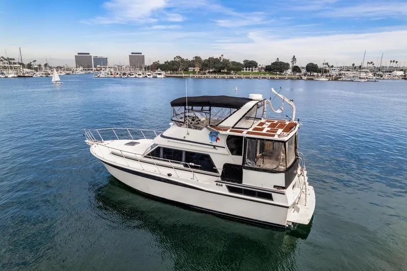 Slide: The Image of 1988 Marine Trader Trawler on calm waters near marina, clear sky background. - 3