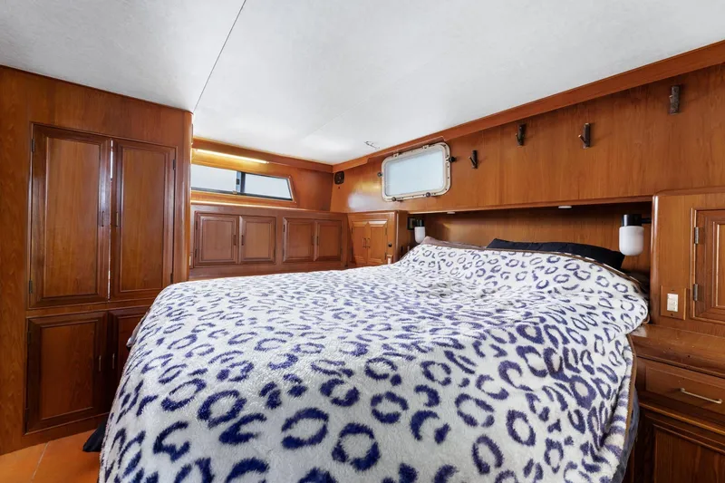 Slide: The Image of 1988 Marine Trader Trawler cabin with cozy bed and wooden interior design. - 30