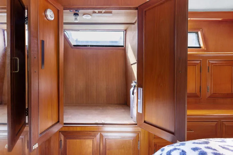 Slide: The Image of 1988 Marine Trader Trawler interior with wooden cabinetry and storage space. - 33