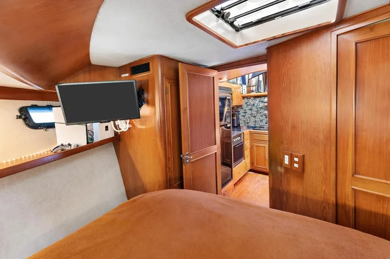 Slide: The Image of 1988 Marine Trader Trawler interior with wood paneling, TV, and kitchen view. - 40