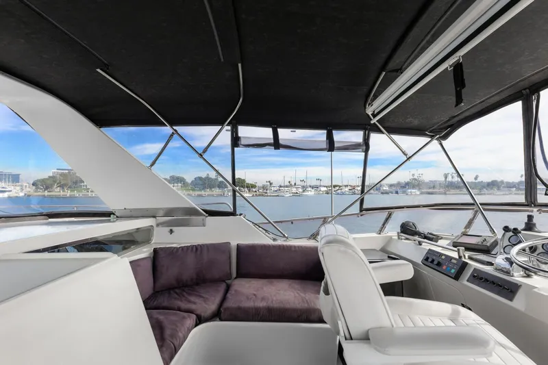 Slide: The Image of 1988 Marine Trader Trawler interior with plush seating and panoramic marina view. - 46