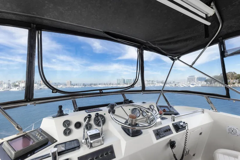 Slide: The Image of 1988 Marine Trader Trawler helm with ocean view, featuring navigation instruments and steering wheel. - 47