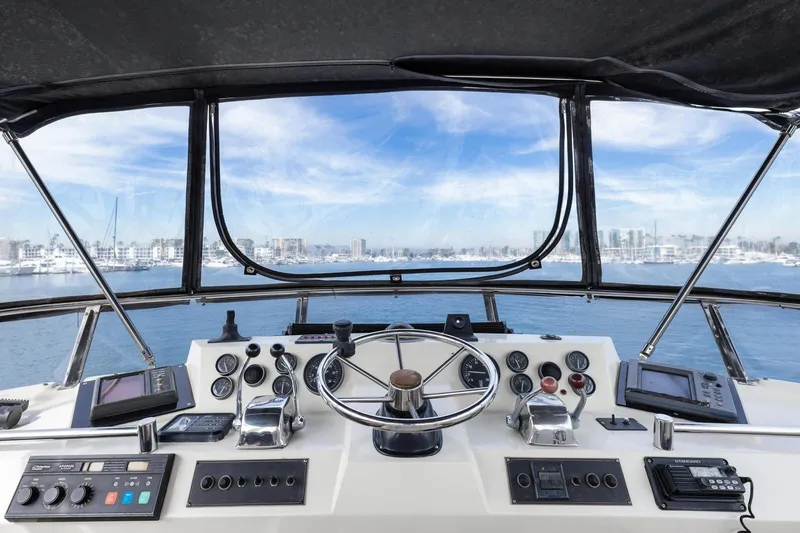Slide: The Image of Cockpit view of a 1988 Marine Trader Trawler with navigational instruments and ocean scenery. - 49