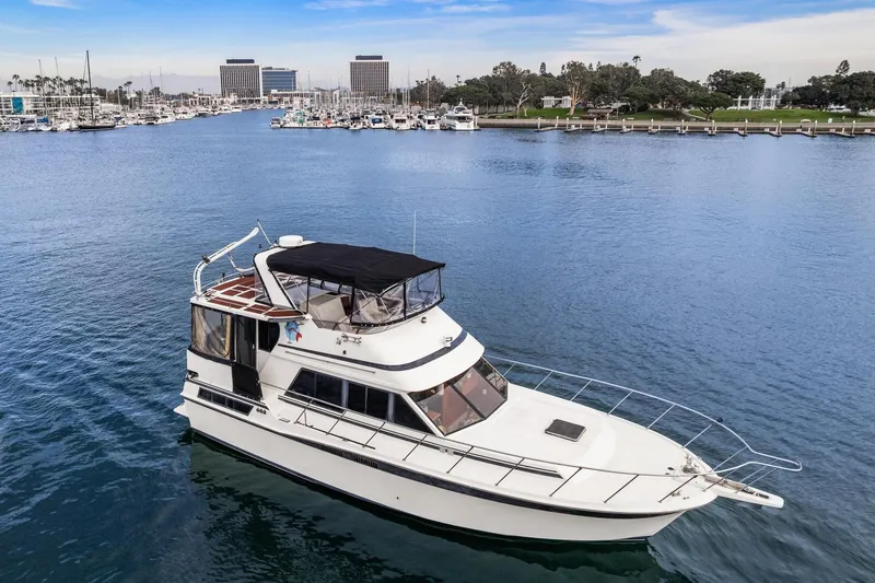 Slide: The Image of 1988 Marine Trader Trawler cruising in a scenic marina with clear blue water. - 5